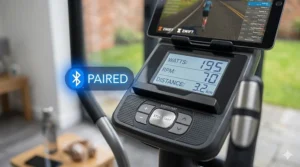 Close-up of a cross trainer console showing the Bluetooth icon successfully paired with the Zwift app.