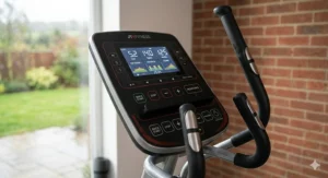 Close-up of the backlit LCD console on a heavy duty cross trainer, displaying workout programmes and metric units including kilometres and beats per minute.
