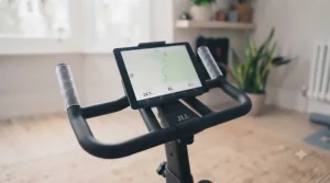 A tablet mounted on the handlebars of a home exercise bike, displaying a virtual route for an engaging training experience.