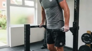 Parallel dip bars attached to a multi-functional power rack for bodyweight exercises.